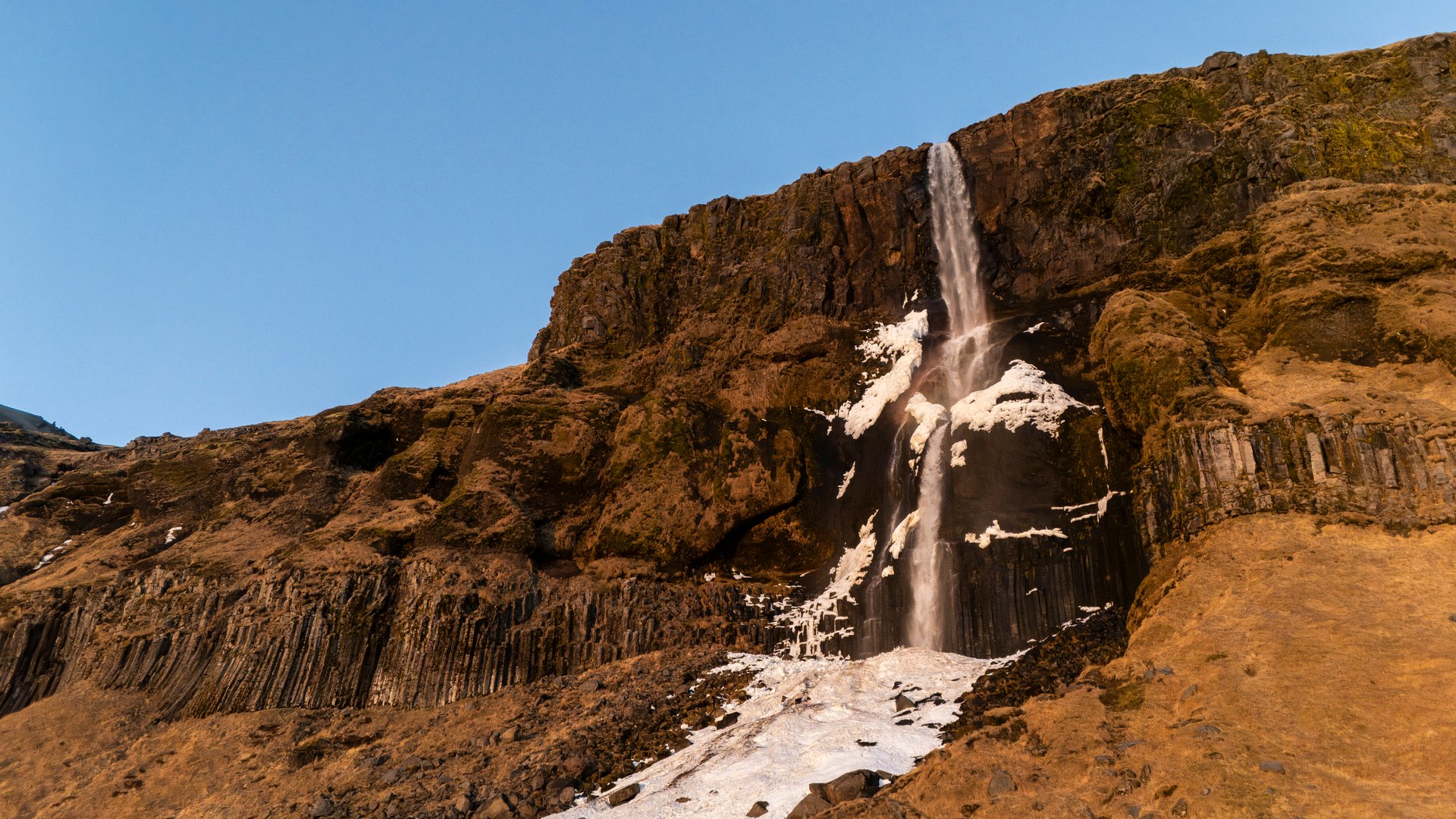 Slender waterfall of Bjarnafoss with the Atlantic Ocean behind