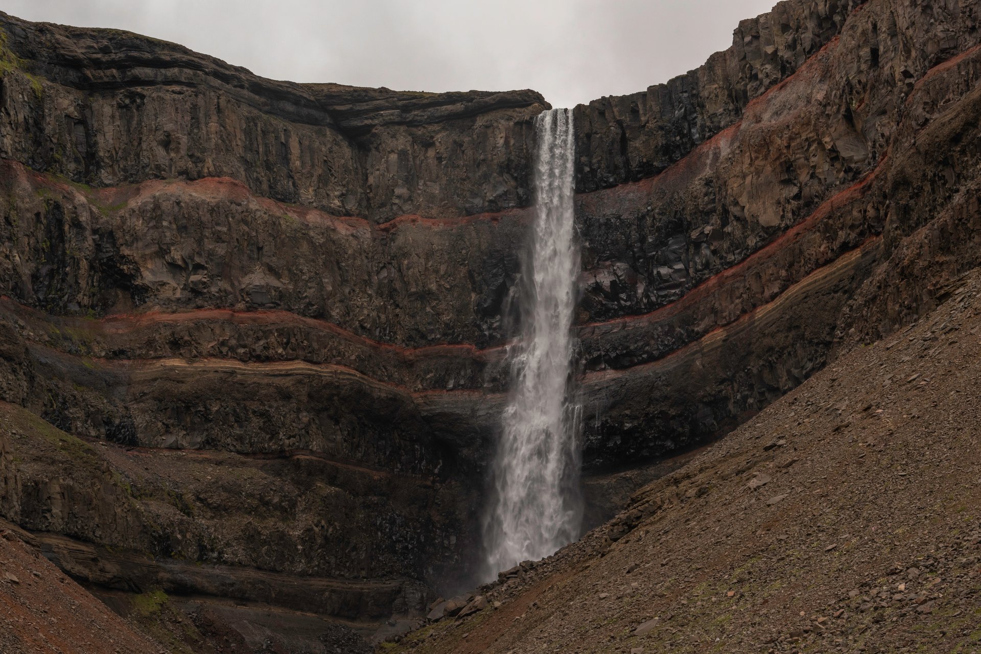 Hengifoss waterfall with red clay and basalt striped cliff face