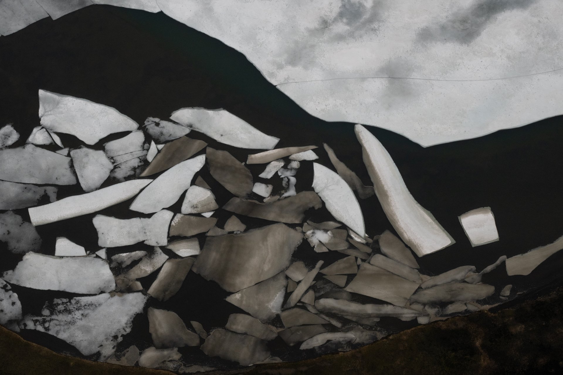 Helicopter view over vast Icelandic glacier with crevasse patterns
