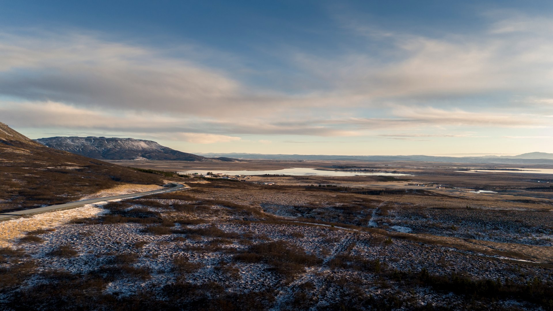 Icelandic road winding through green valleys and mountains
