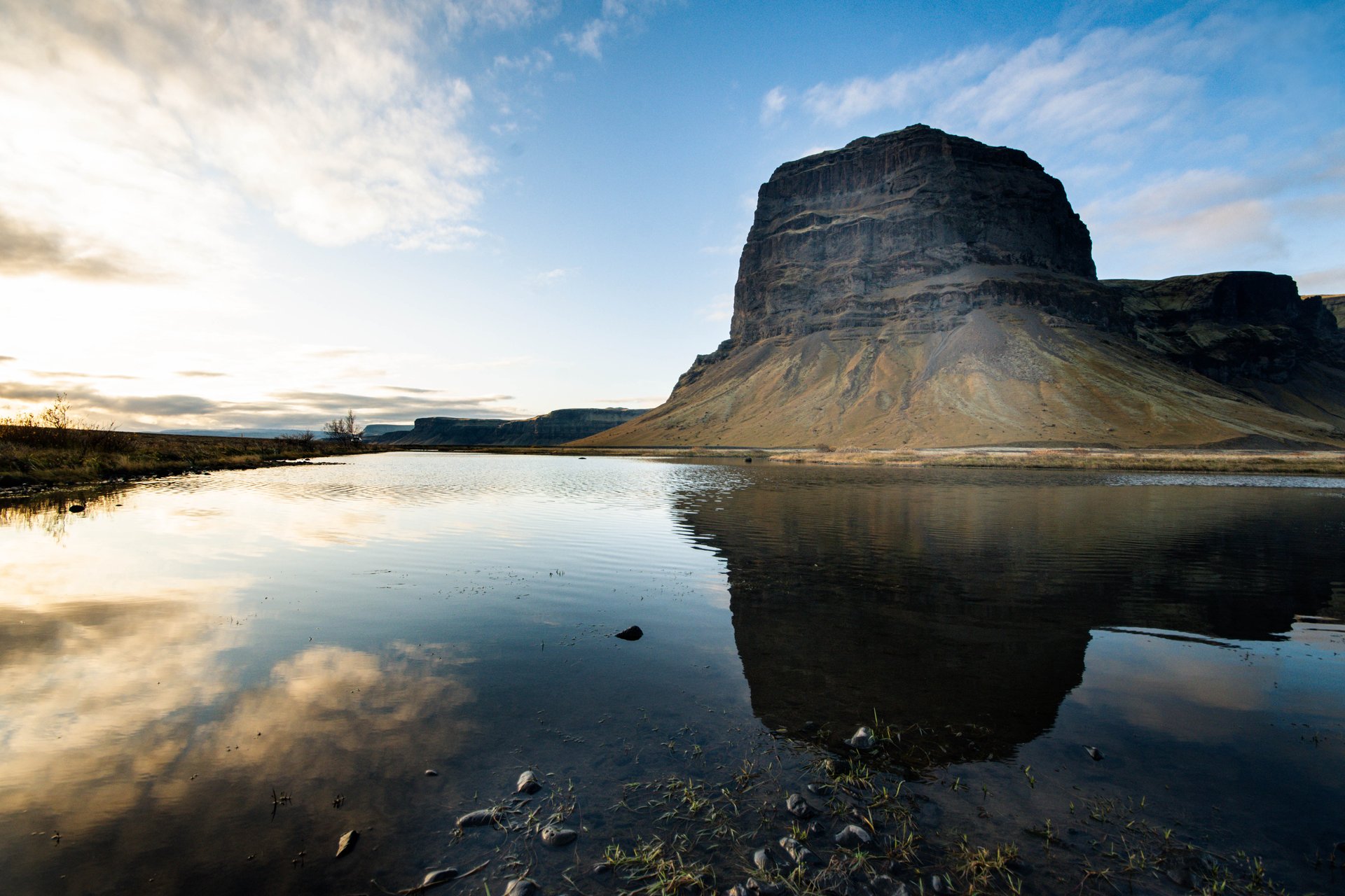 Road through Iceland with open landscape and distant mountains