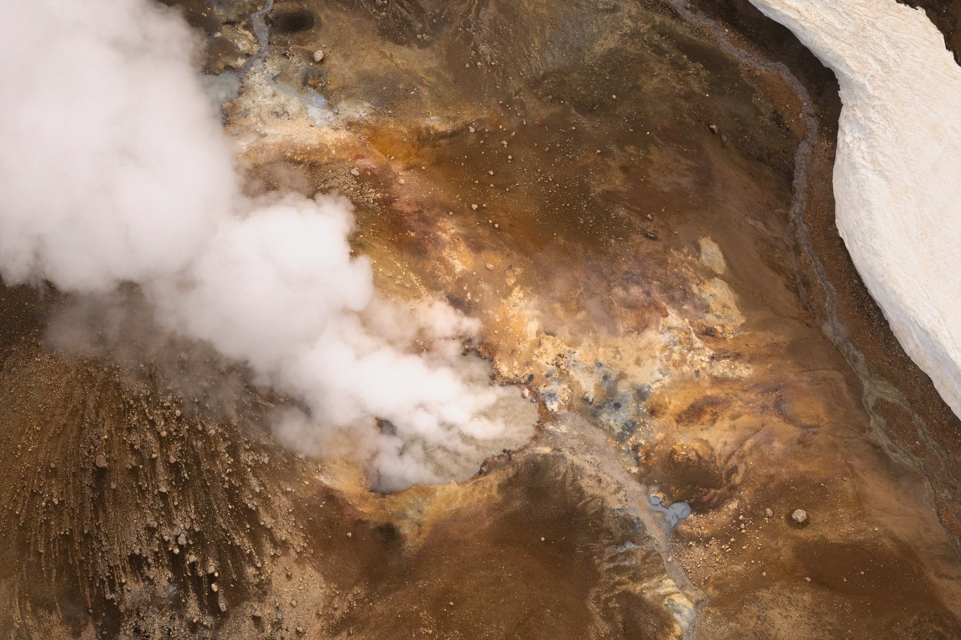 Helicopter flying over colorful Landmannalaugar geothermal mountains and glaciers