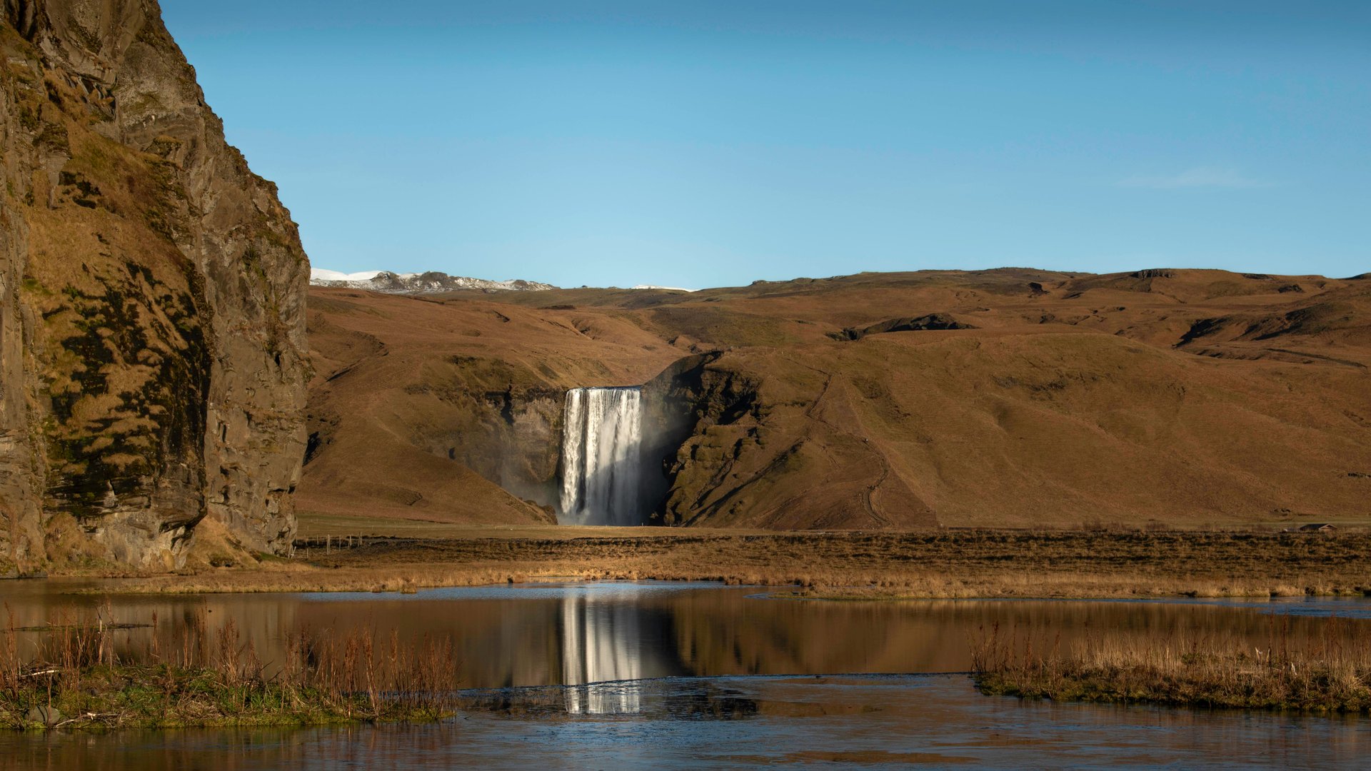 Cascade de Skógafoss dans la lumière dorée du soleil de minuit