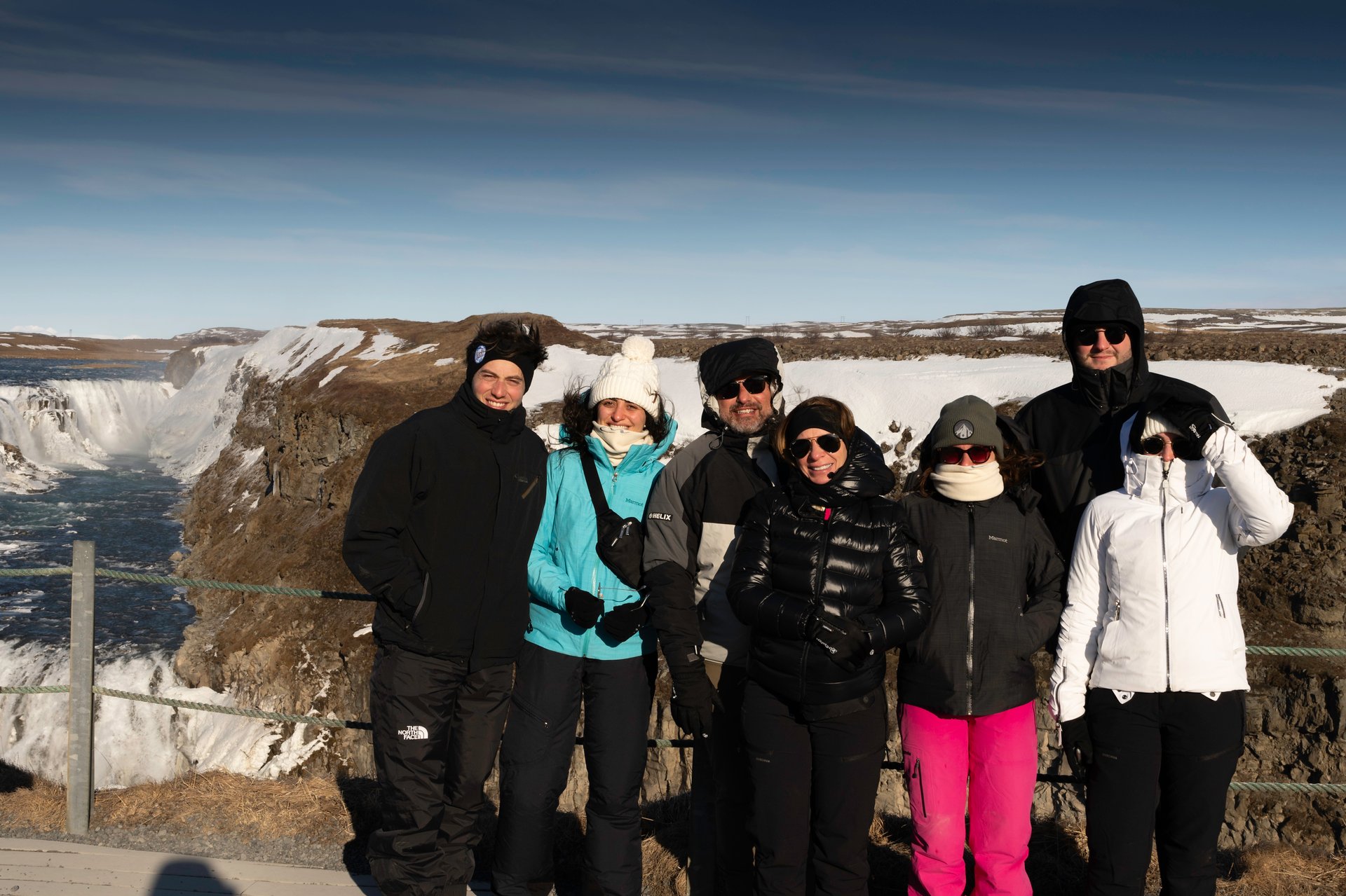 Small group tour in Iceland with guide and travelers at waterfall