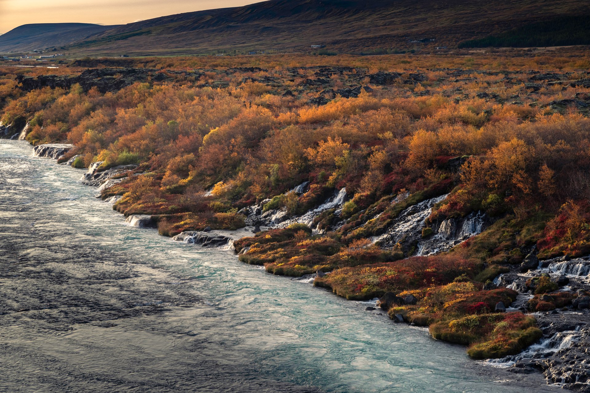 Hraunfossar panoramic view with turquoise glacial water and lava formations