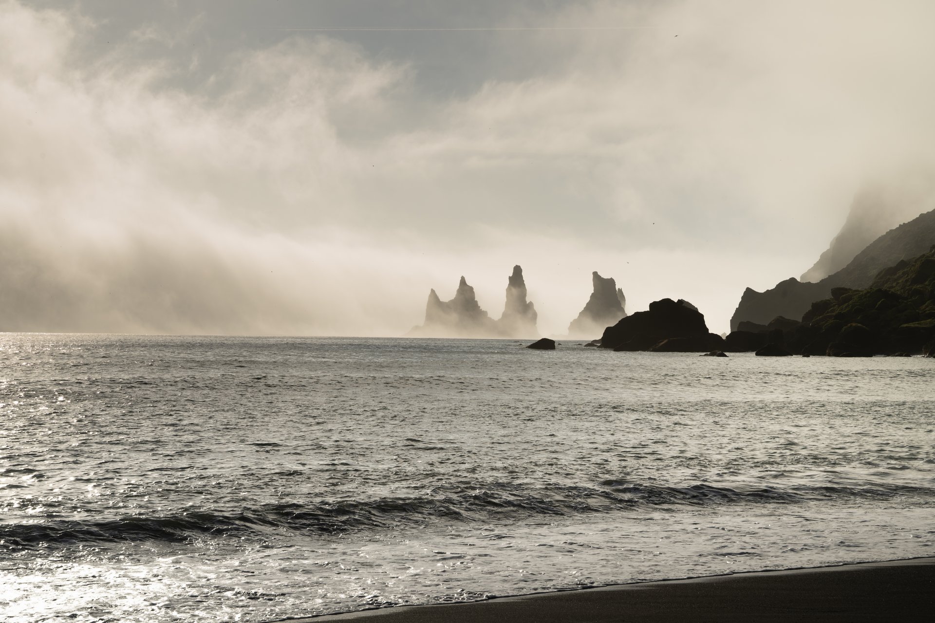 Wide view of Víkurfjara beach showing the open stretch of black sand