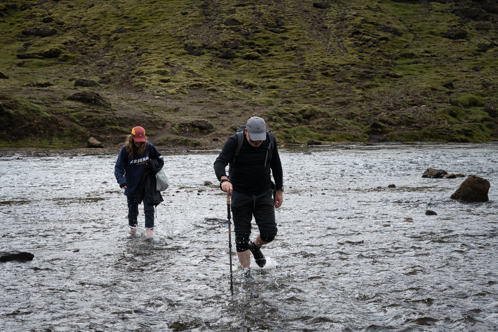 Clients crossing a river on a summer hiking tour — sandals are essential for river crossings