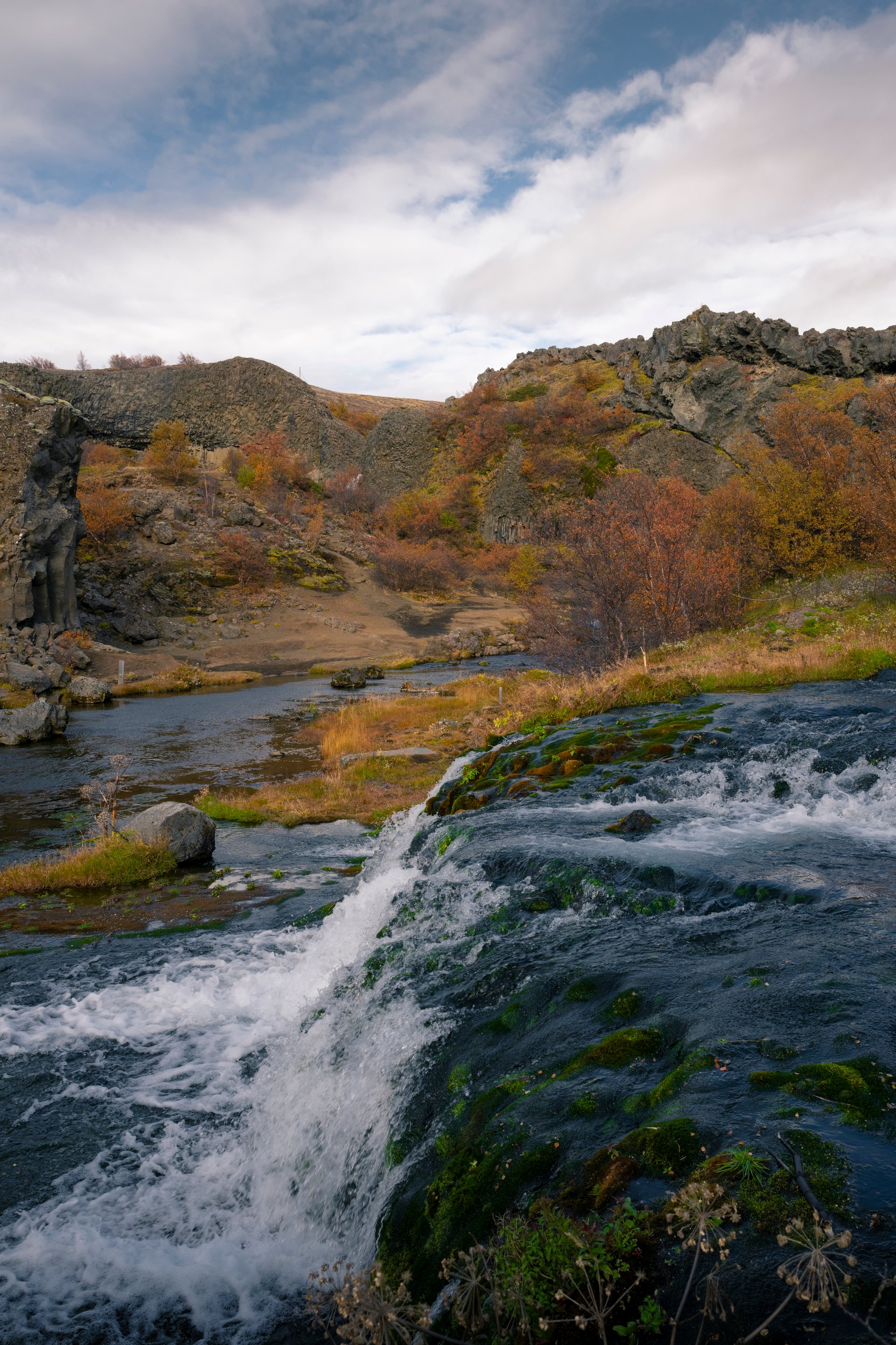 Vallon de Gjáin avec petites cascades et végétation verte luxuriante