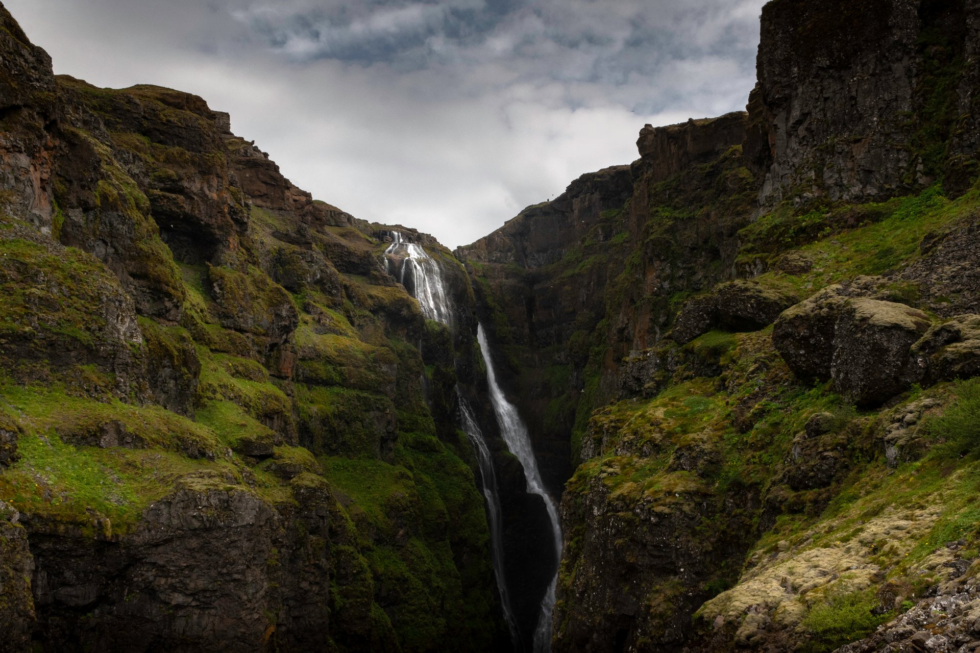 Spectacular Glymur waterfall cascading through dramatic canyon landscape