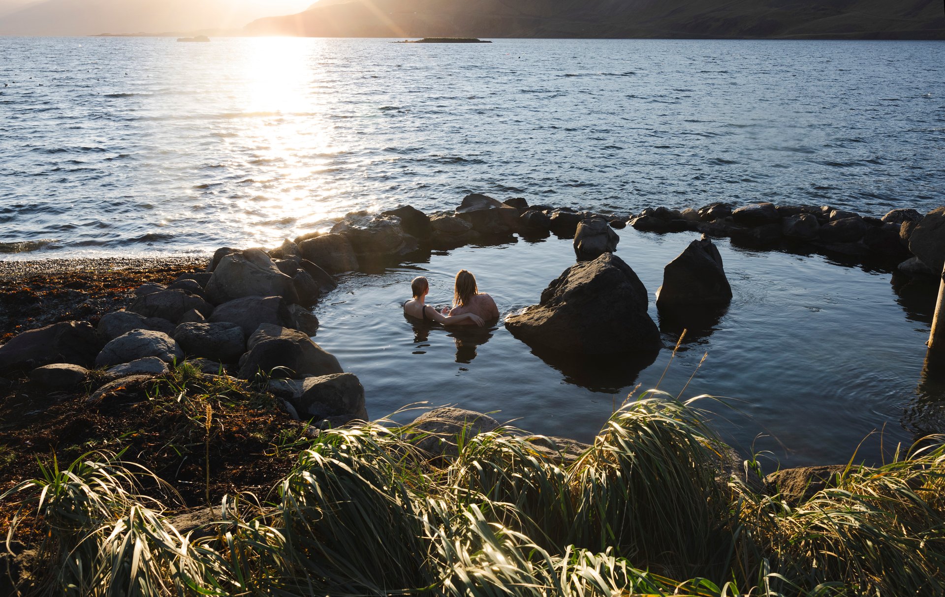 Coastal hot springs with mountain backdrop at Hvammsvík Iceland