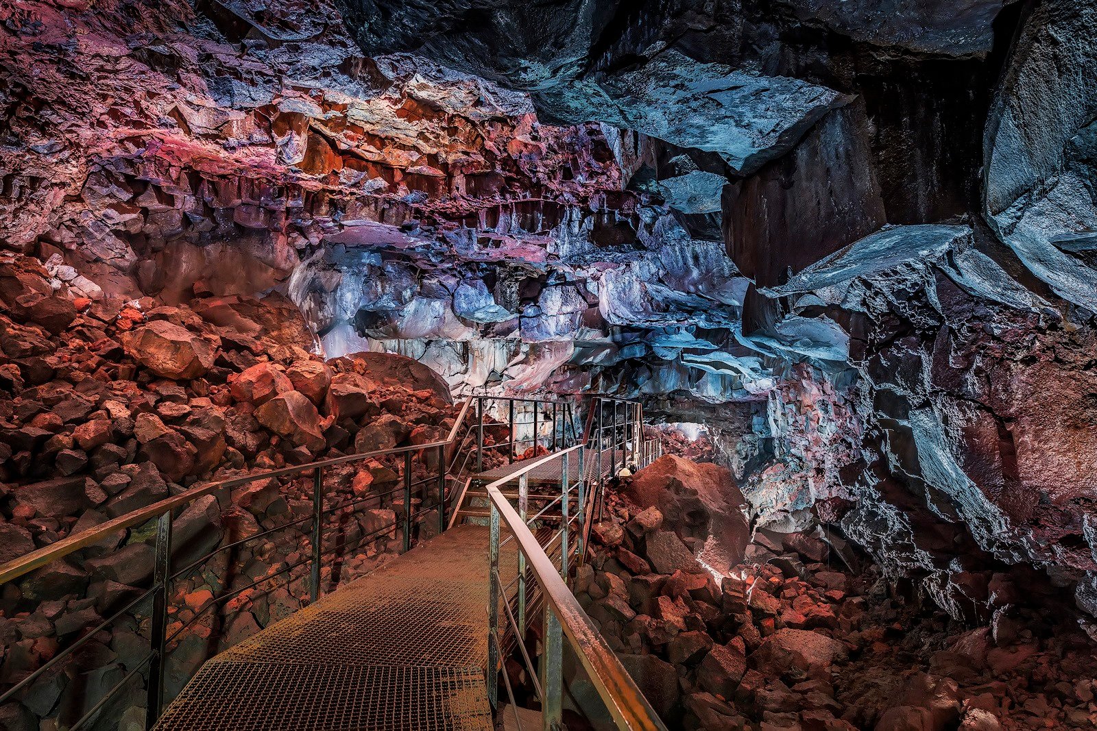 Illuminated Raufarhólshellir lava tunnel showing volcanic rock formations