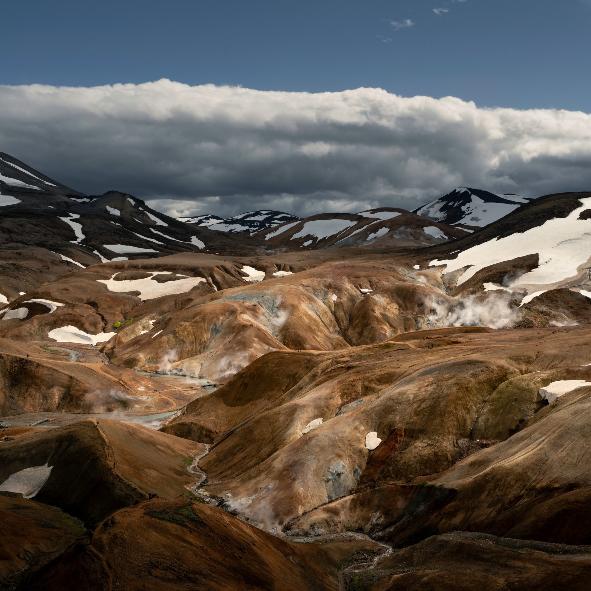 Bubbling mud pots and geothermal features in highland valley