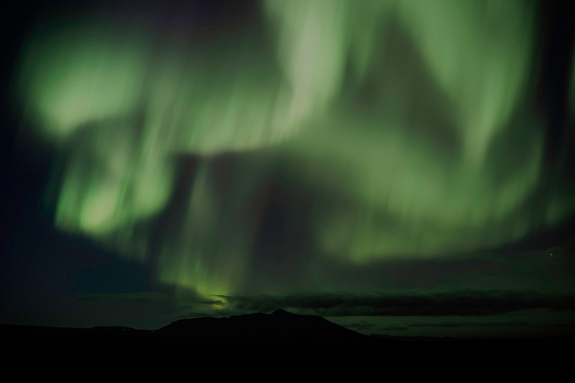 Magical Northern Lights Aurora Borealis dancing across Iceland's night sky with dramatic landscape