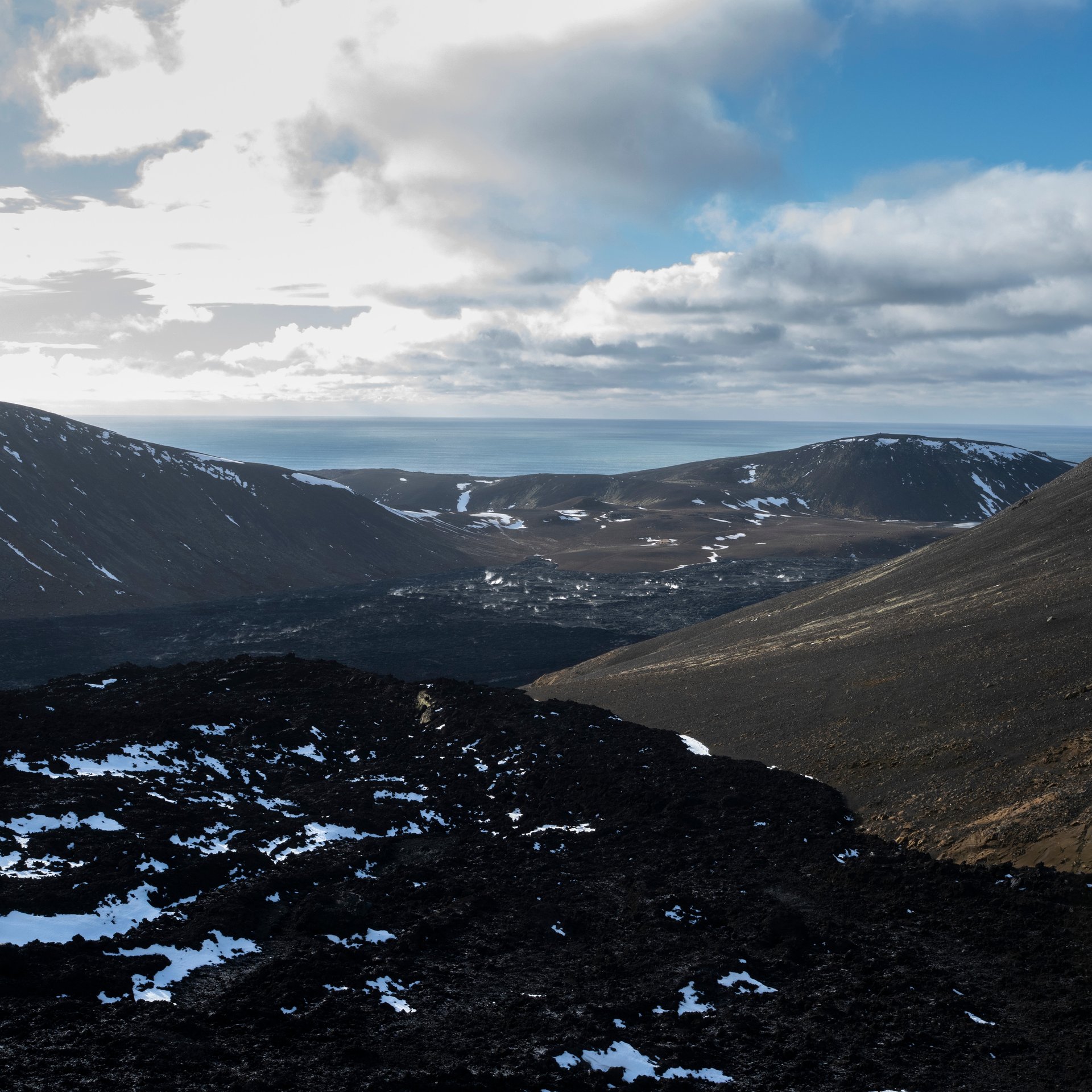 Randonneurs sur le sentier du volcan Fagradalsfjall avec champs de lave et point de vue sur le cratère