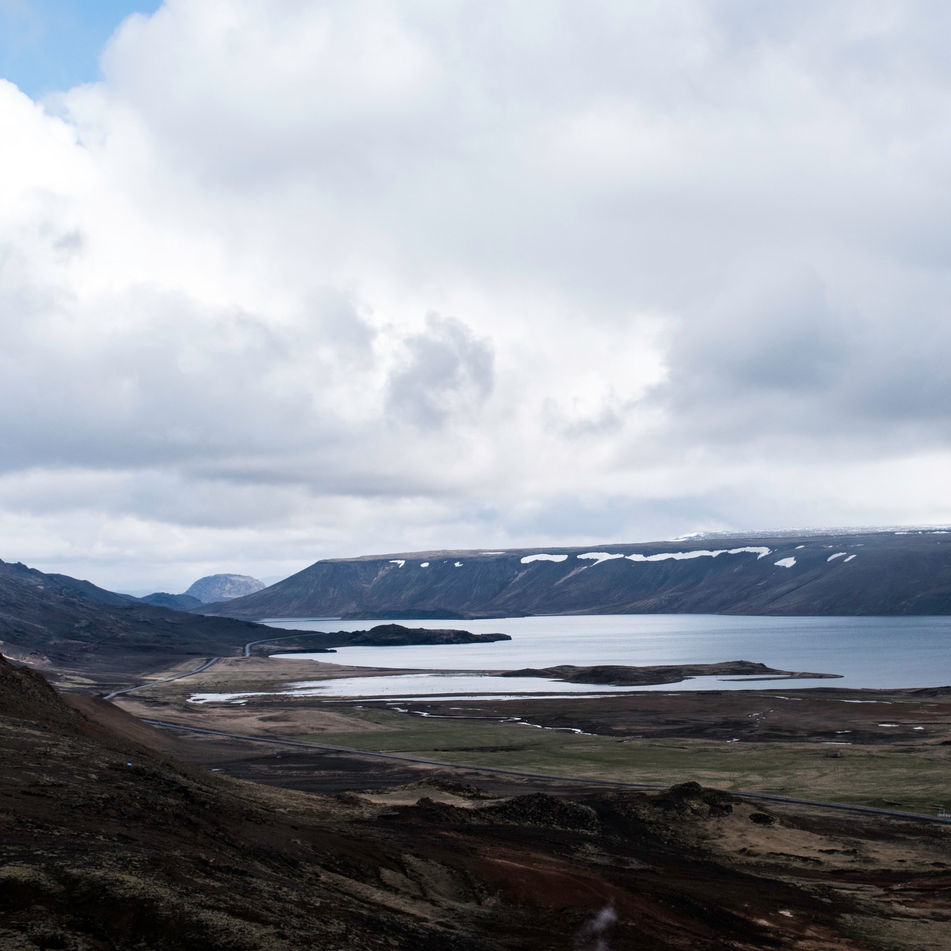 Lac volcanique Kleifarvatn avec rives de sable noir et reflets montagneux sur la péninsule de Reykjanes