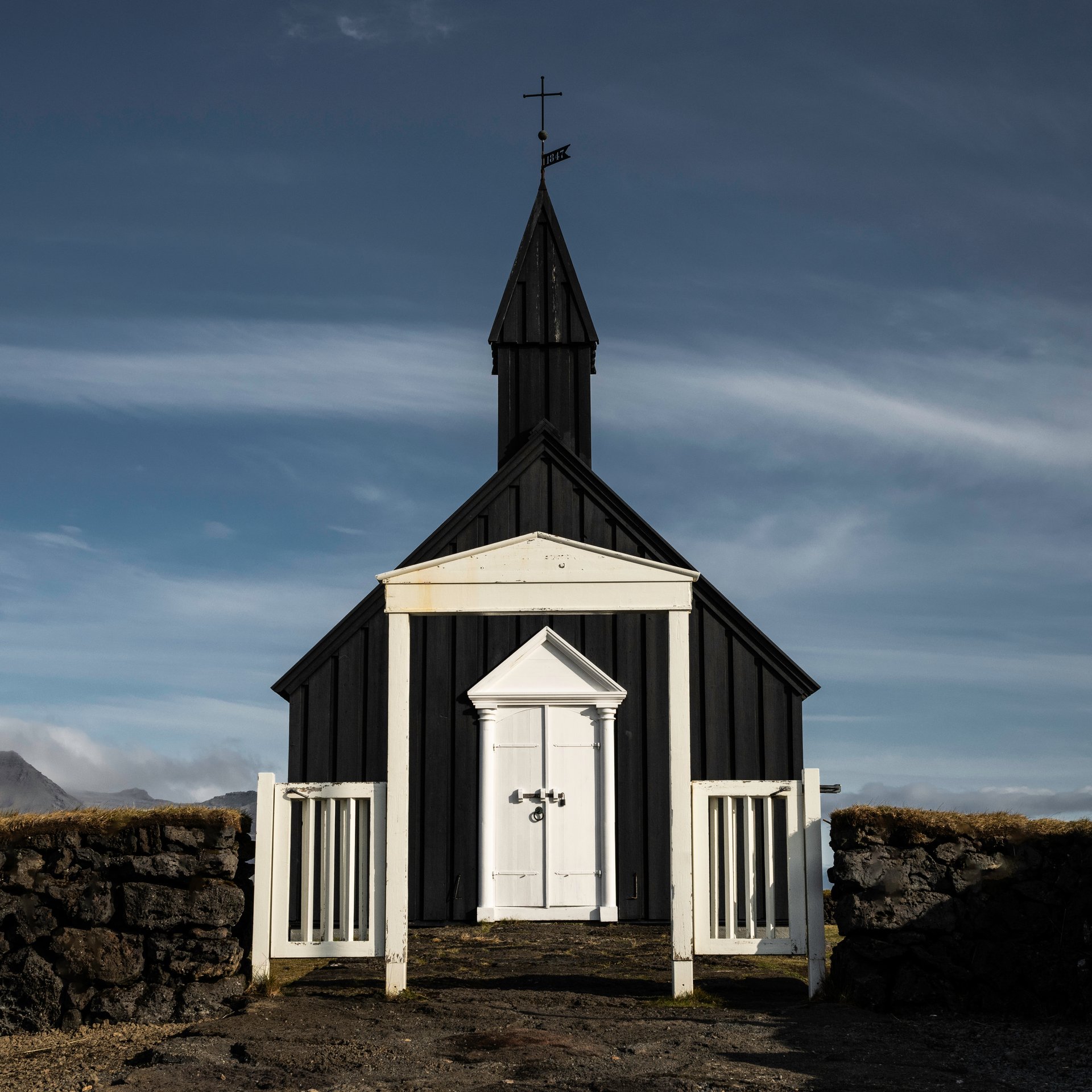 Búðakirkja black church standing against golden grass and dramatic lava fields