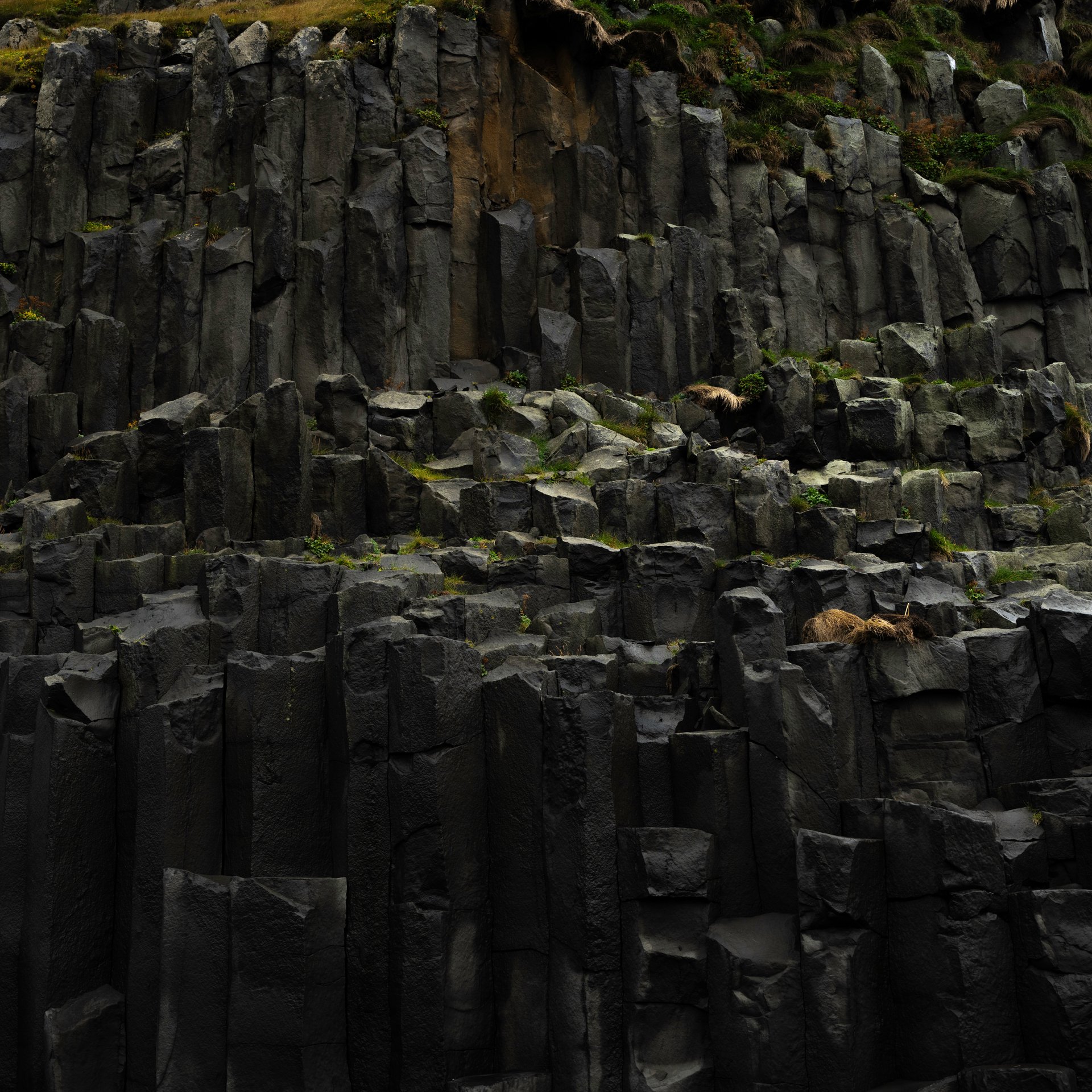 Dramatic Reynisfjara black sand beach with basalt sea stacks and geometric cliff formations